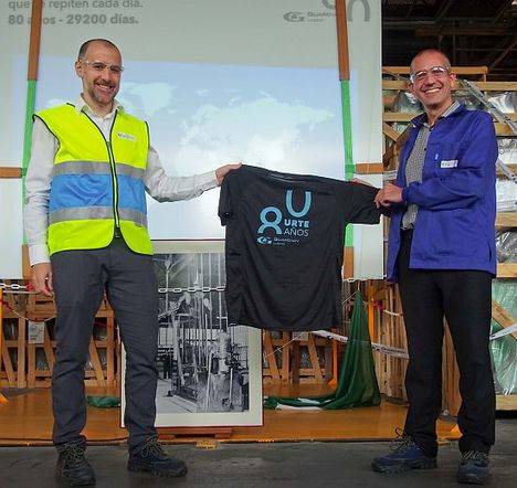 Javier García (izquierda), Director de la planta Llodio Flat Glass, y Enrique Martínez, Director de la planta de Llodio Automotive, muestran la camiseta hecha a medida para conmemorar el 80 aniversario de la planta durante la celebración del 29 de octubre en las instalaciones. 